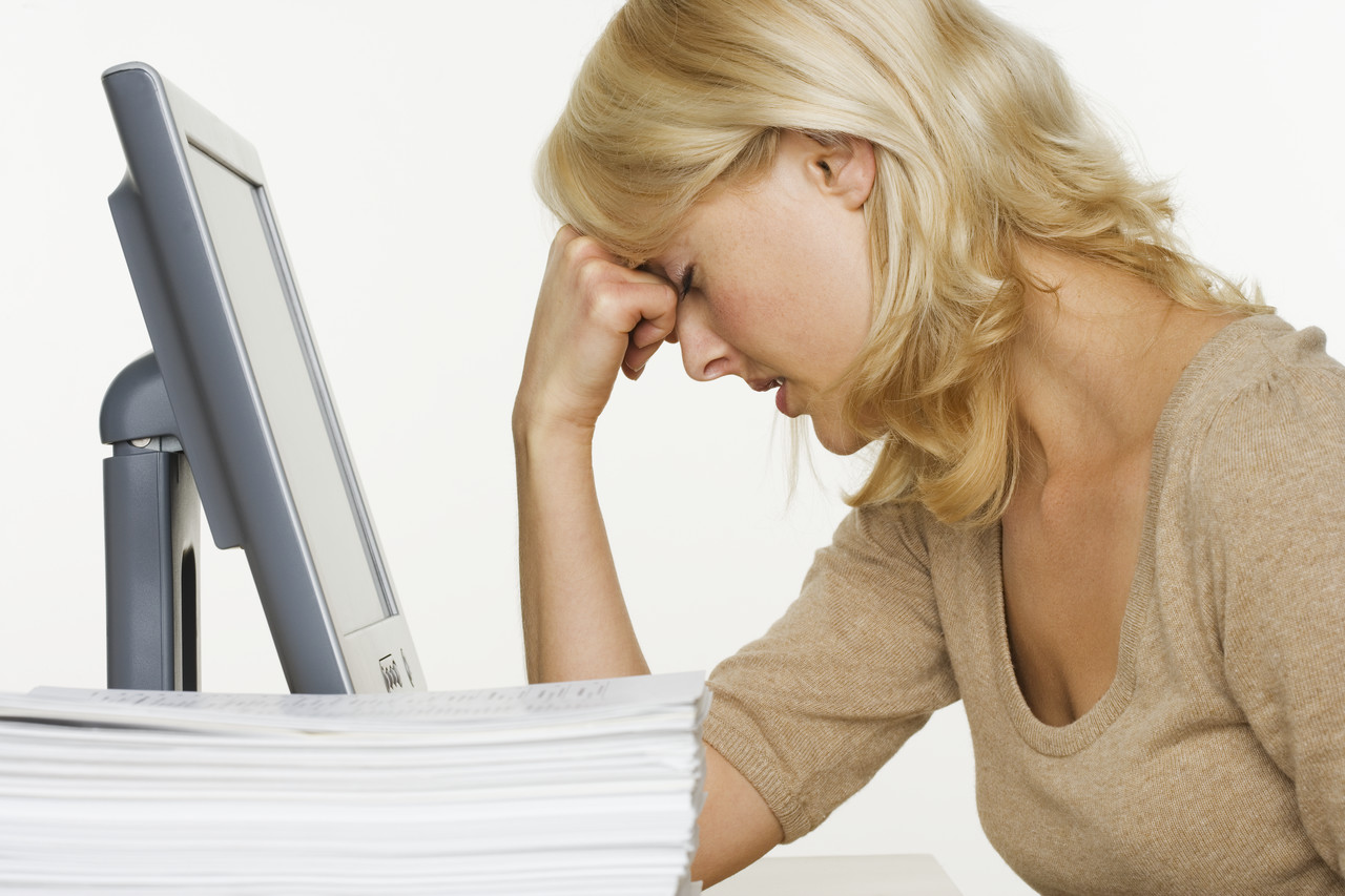 Frustrated Woman at Computer With Stack of Paper --- Image by © Royalty-Free/Corbis